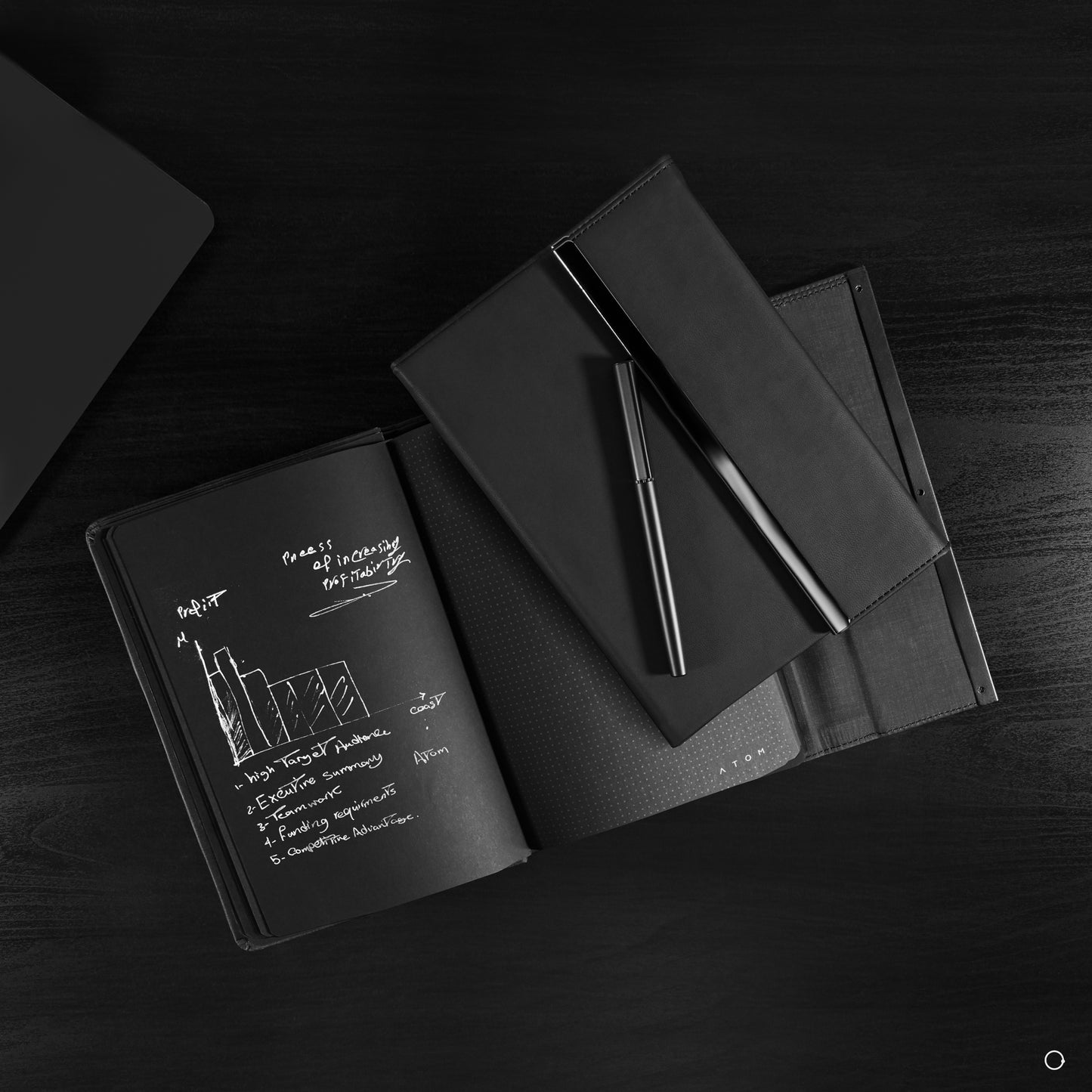 Black notebook and silver pen